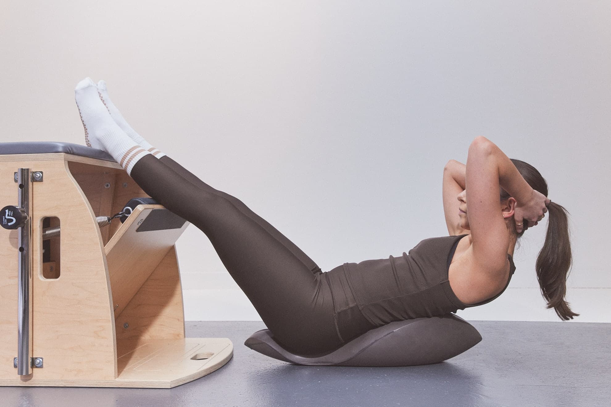 Une cliente relevant le haut du corps sur un Oov, les deux pieds appuyés sur la Wunda Chair