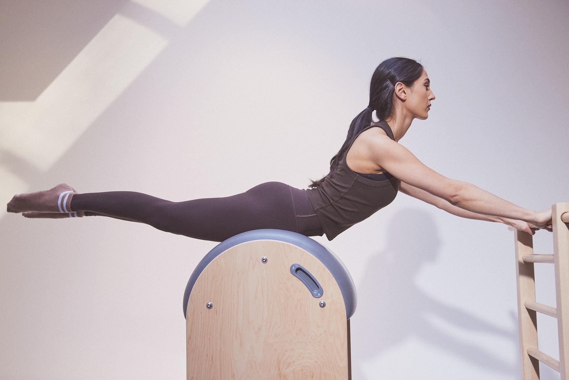 Une cliente en extension sur le Ladder Barrel chez MTLPILATES