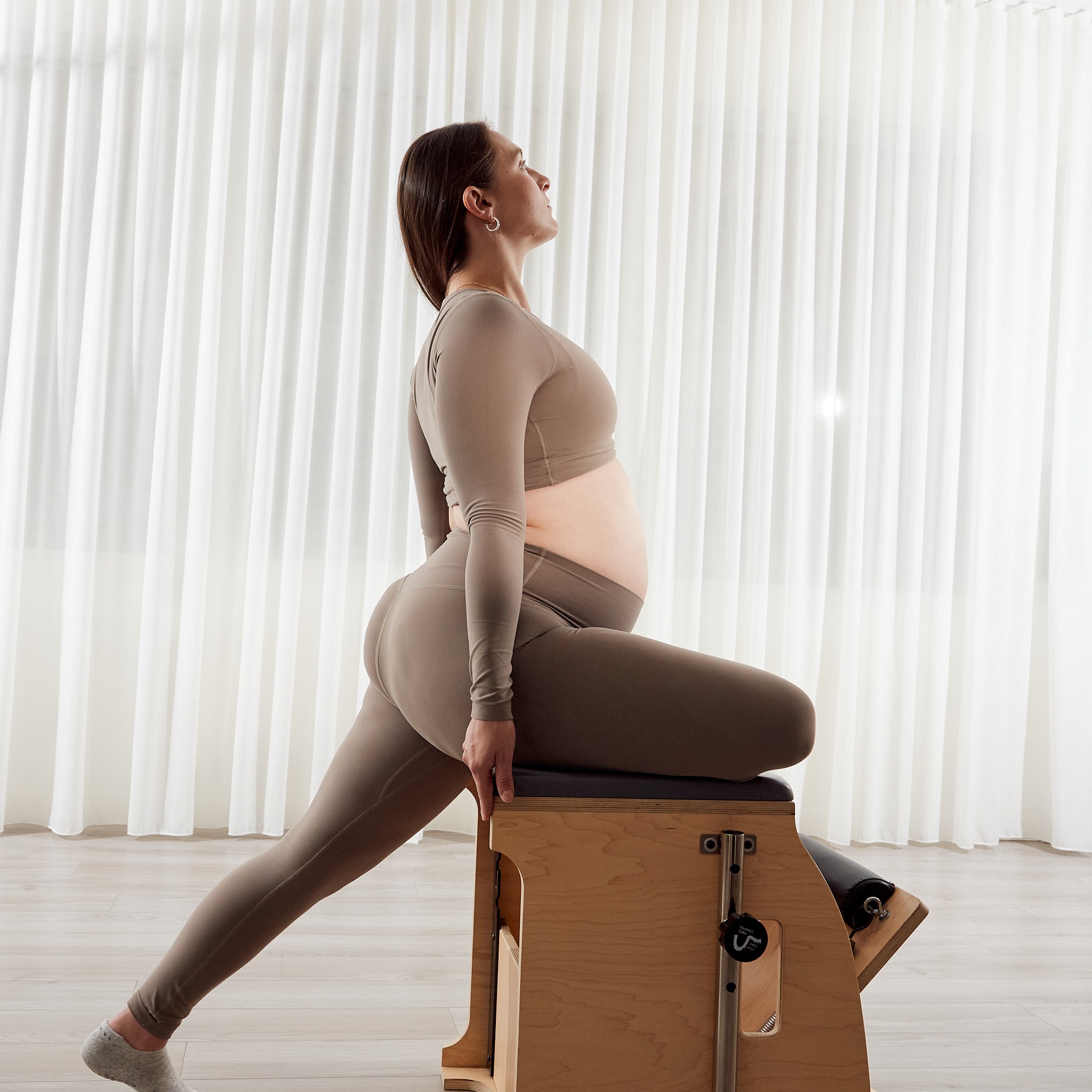 A prenatal client practising Pilates on studio apparatus at MTLPILATES